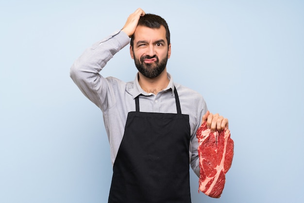 Chef holding a raw meat with an expression of frustration and not understanding