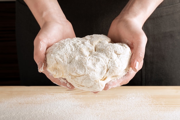 Foto lo chef tiene l'impasto per la cottura