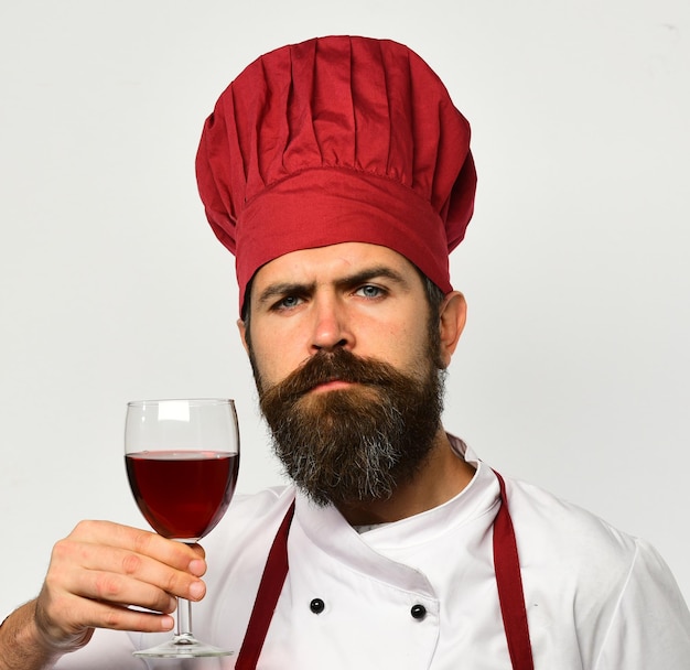 Chef holds glass of red wine Man with beard