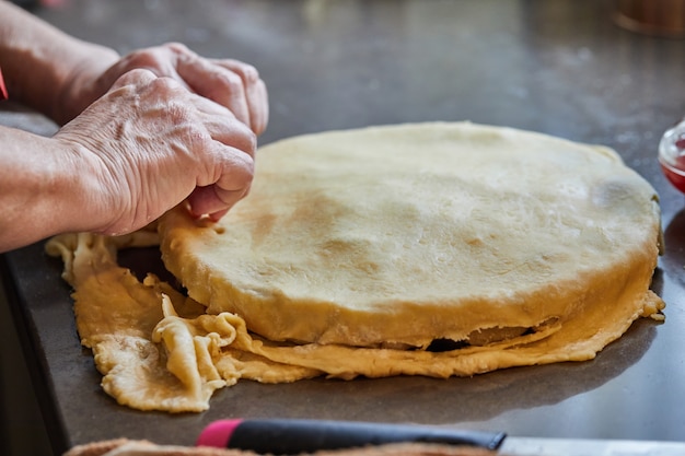 Chef is covering the filling for the chard pie with dough. Step by step recipe.