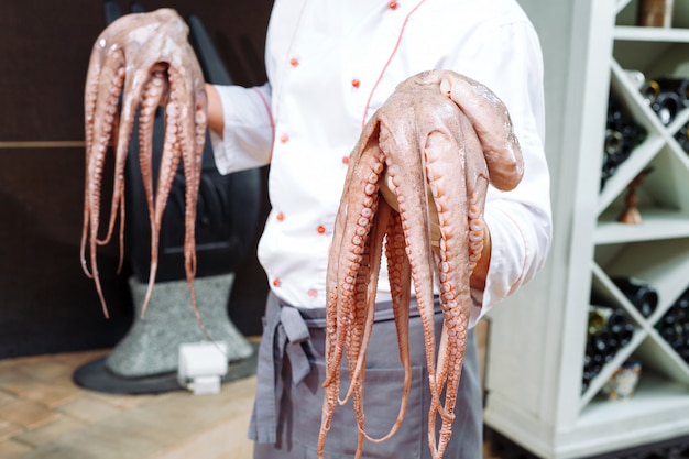 The chef is holding an octopus.