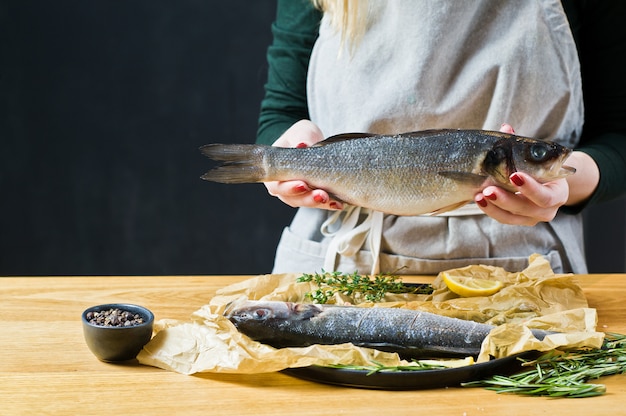 The chef is holding a sea bass. 