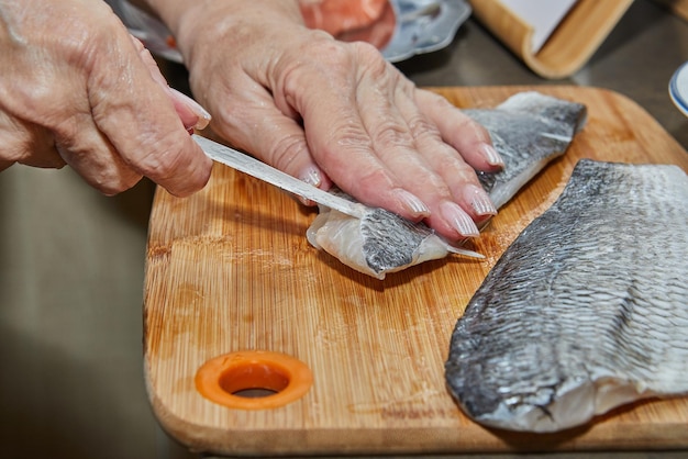 Photo chef is skinning salmon fillets for cooking