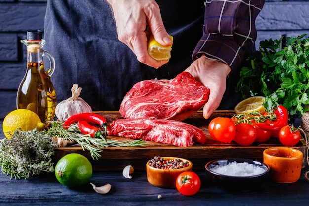 Lo chef sta spruzzando il succo di limone sulla bistecca di manzo