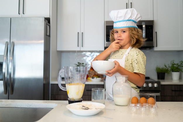 Chef kid cook baking at home kitchen Kid chef cook cookery at kitchen Cooking culinary and kids Little boy in chefs hat and apron
