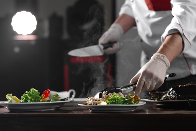 The chef in the kitchen unloading fish onto plates