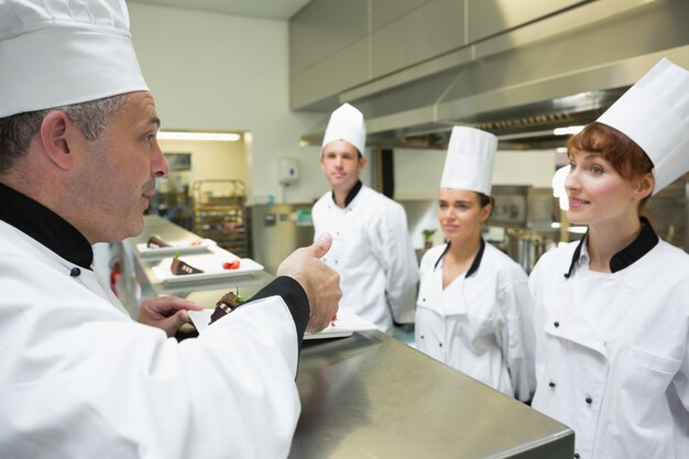 Chef-kok beoordeelt de plaat van een van zijn leerlingen