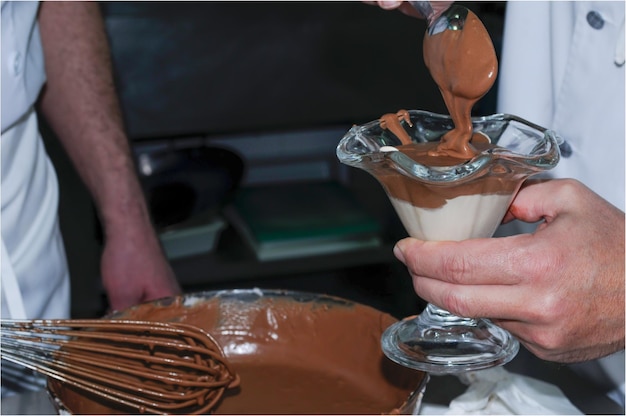 Chef-kok bereidt chocolademousse in een glazen beker