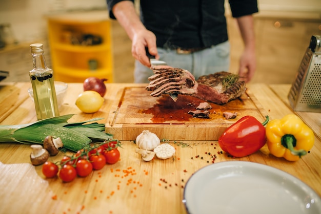 Chef-kok bij de pan met geroosterd vlees en vetables