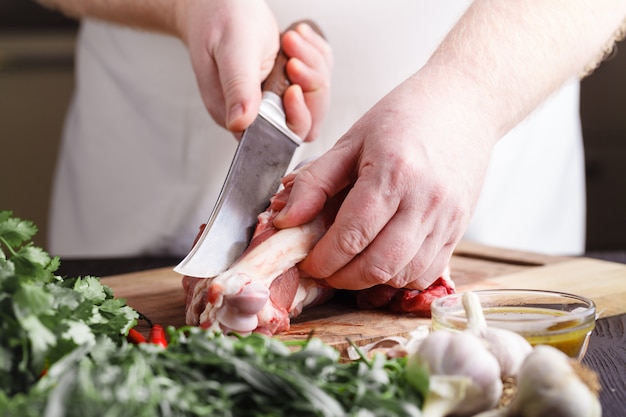 Chef-kok Butcher snijden lamsvlees met mes