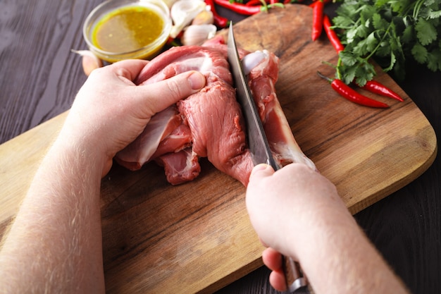 Chef-kok Butcher snijden lamsvlees met mes