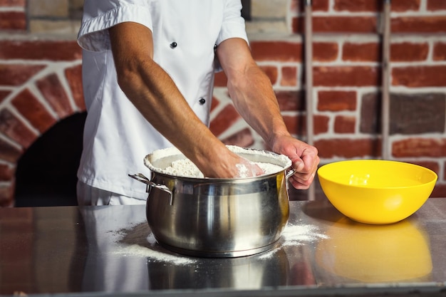 Chef-kok deeg maken voor pizza Man handen bereiden brood Concept van bakken en patisserie