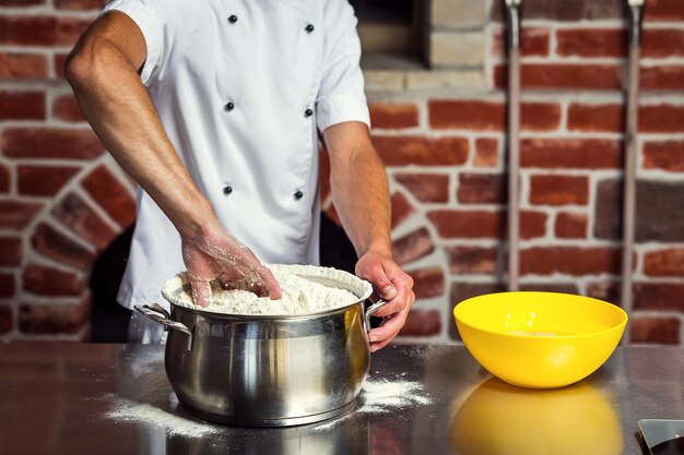 Chef-kok deeg maken voor pizza Man handen bereiden brood Concept van bakken en patisserie