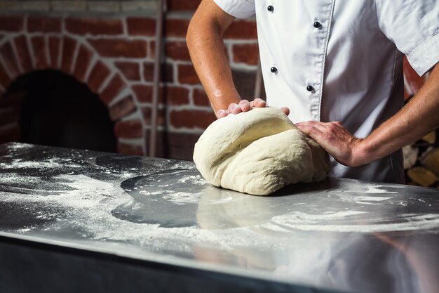 Chef-kok deeg maken voor pizza Man handen bereiden brood Concept van bakken en patisserie