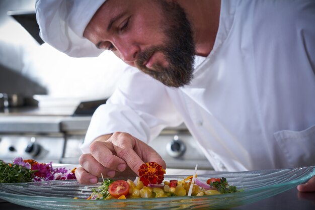 Foto chef-kok die bloem in cevicheschotel versiert