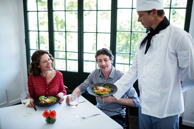 Chef-kok die de te koppelen maaltijdplaat toont