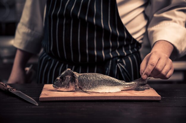 Chef-kok die de vis op een bord snijdt?