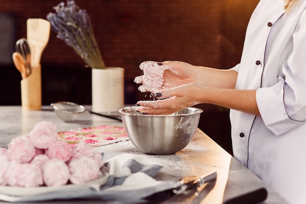 Chef-kok die delicate zelfgemaakte marshmallows met haar handen. Het concept van thuis koken.