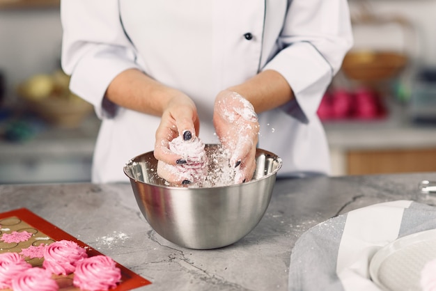 Chef-kok die delicate zelfgemaakte marshmallows met haar handen. Het concept van thuis koken.