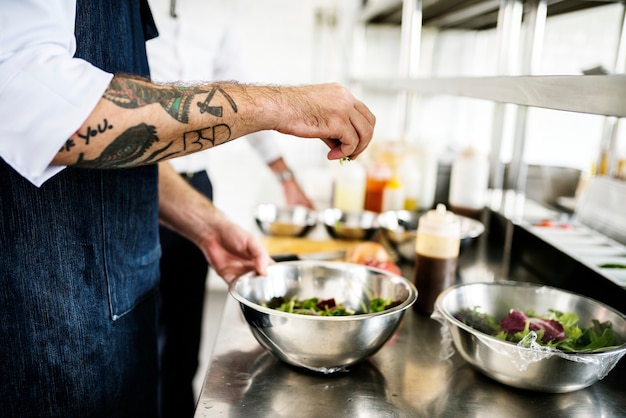 Chef-kok die en in de keuken werkt kookt