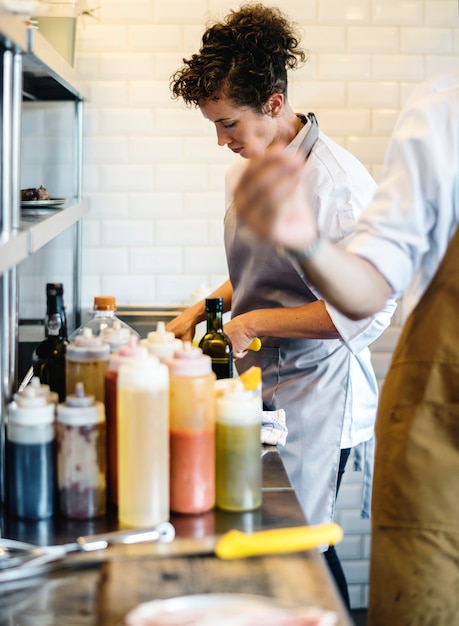 Chef-kok die en in de keuken werkt kookt