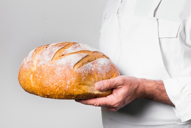 Foto chef-kok die heerlijk gebakken brood houdt