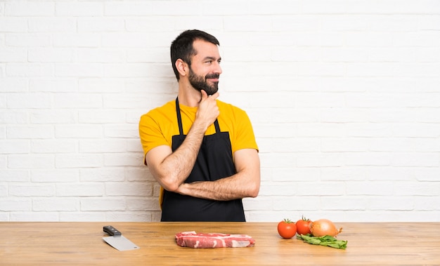 Chef-kok die in een keuken houdt die aan de kant kijkt