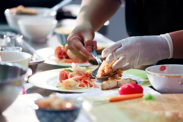 Chef-kok die voedsel, maaltijd, in de keuken, chef-kok koken voorbereiden, chef-kok die schotel, close-up verfraaien