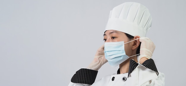 Chef-kok draagt een beschermend medisch masker of gasmasker voor bescherming tegen virusziekte. Voedselveiligheid en pandemie van het coronavirus. chef-kok poseren gebaar vertegenwoordigen online bestellen. voedsel gezondheidszorg.