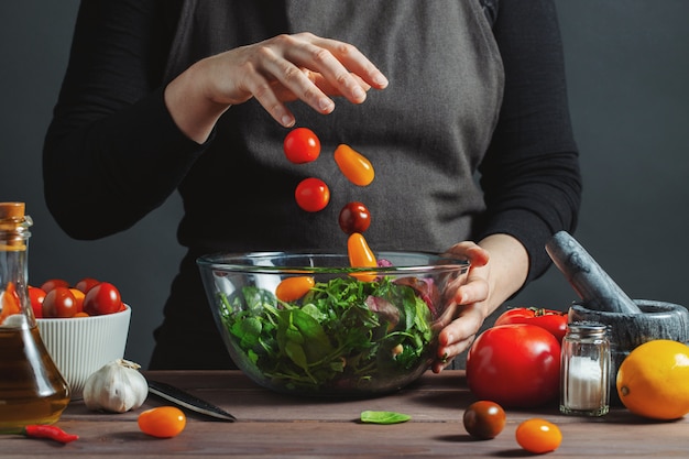 Chef-kok giet cherrytomaatjes in een kom