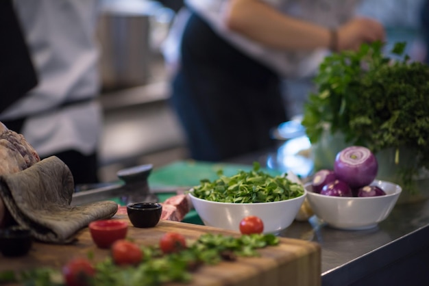 chef-kok hand portie groentesalade op bord in restaurant keuken