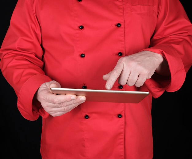 Chef-kok in rode uniform met een elektronische tablet