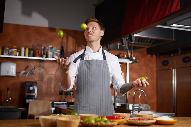 Chef-kok jonglerende vruchten in keuken