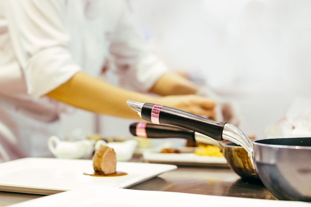 Chef-kok koken, Chef-kok bereiden van voedsel, chef-kok versieren schotel in de keuken