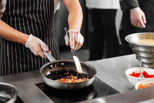 Chef-kok koken groenten op een koekenpan