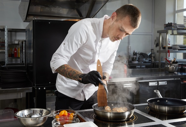 Chef-kok koken in de moderne keuken in het restaurant van het hotel garnalensalade bereiden