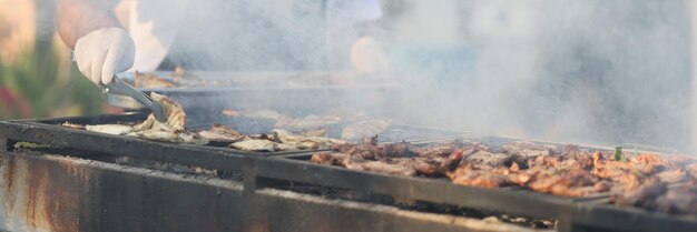 Chef-kok kokend vlees op houtskool buiten hotelclose-up