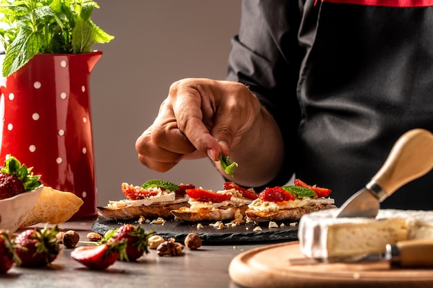 Chef-kok kooktaartjes met room, aardbeien en bosbessen