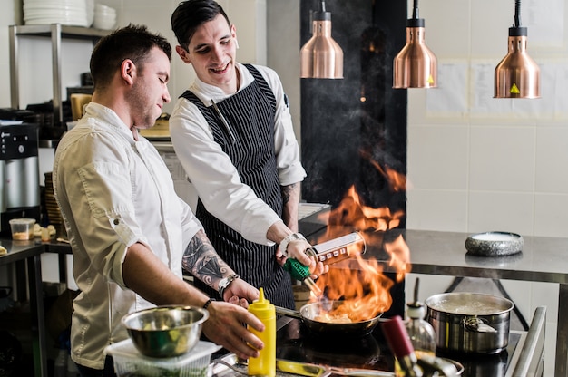 chef-kok maakt flambe in een restaurantkeuken