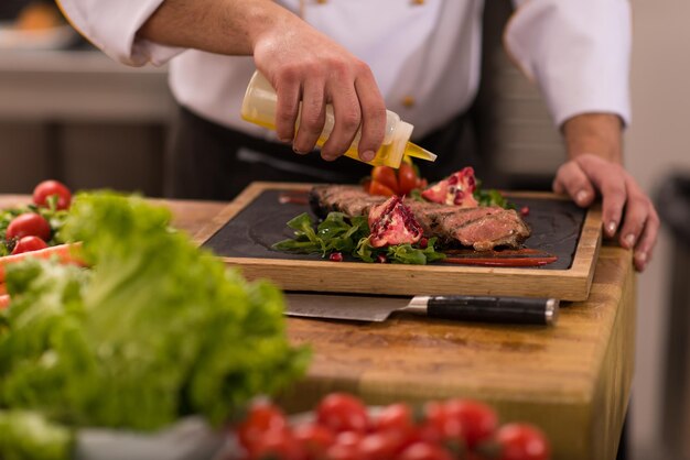 Chef-kok maakt steak vleesbord af met Eindelijk schoteldressing en bijna klaar om aan tafel te serveren