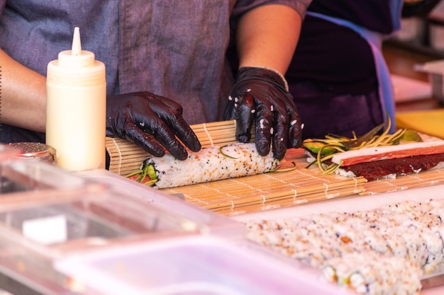 Chef-kok maakt sushi buiten op straatvoedselfestival met open keuken