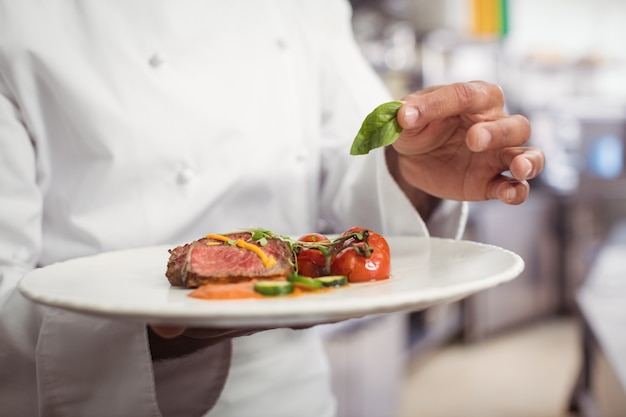 Chef-kok met heerlijke schotel in de keuken