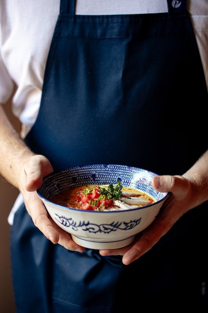 Chef-kok met kom Japanse curry kip ramen