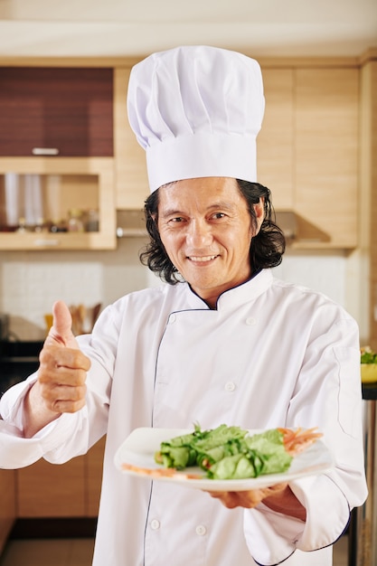 Chef-kok met plaat met snacks