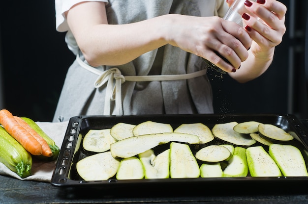 Chef-kok pepers gesneden aubergine.