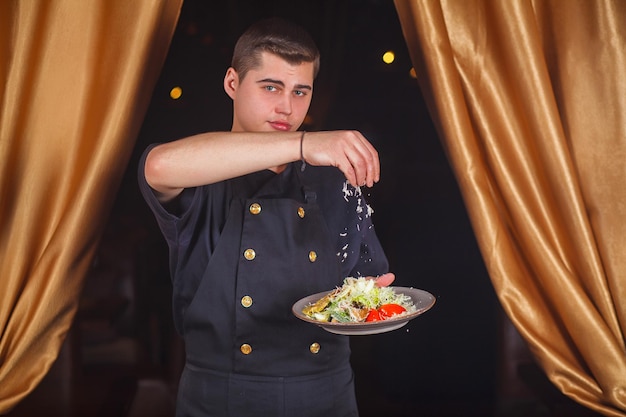 Chef-kok serveert Caesarsalade met Parmezaanse kaas. Chef-kok die een salade voorbereidt.