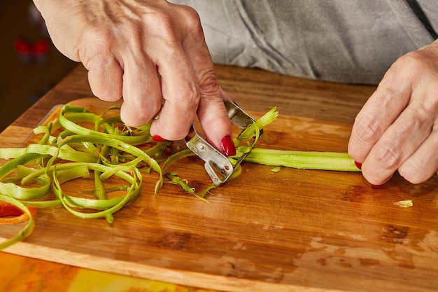 Chef-kok snijdt de asperges in dunne plakjes om het gerecht te bereiden