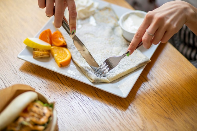 chef-kok snijdt groenten aan boord vrouw aan het ontbijt in restaurant pannenkoeken