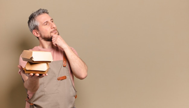 Chef-kok van middelbare leeftijd man met hamburgers. barbecue concept