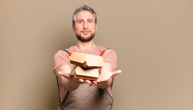 Chef-kok van middelbare leeftijd met hamburgers. barbecue concept